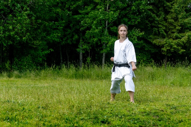 Jugendliche, die im freien karate-kata praktiziert, führt den gedan-barai oder den abwärtsblock durch