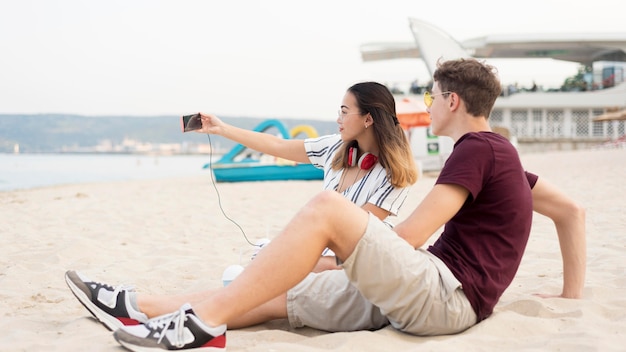 Jugendliche, die zusammen ein Selfie am Strand machen