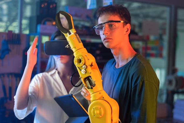 Kostenloses Foto jugendliche machen experimente zur robotik in einem labor. junge mit schutzbrille blickt auf einen roboter