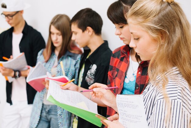 Jugendliche mit Notizblöcken studieren