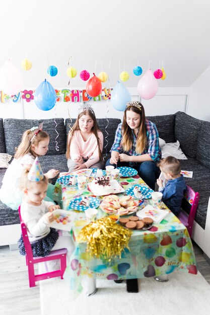 Jugendliche und Kinder, die Kuchen essen