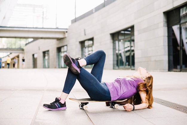 Kostenloses Foto jugendlicher, der auf skateboard liegt