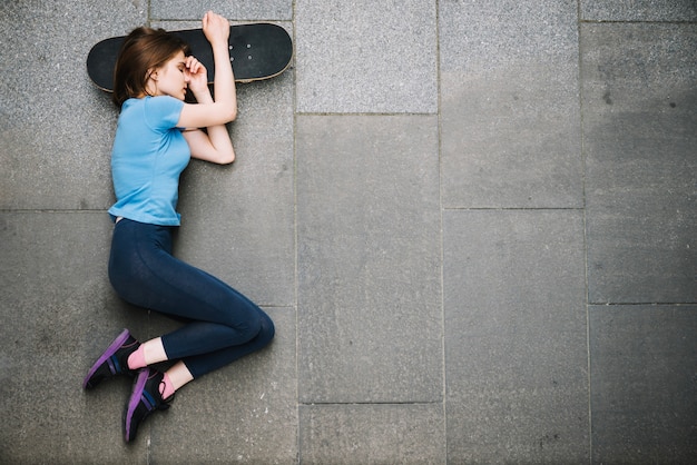 Jugendlicher, der auf Skateboard schläft