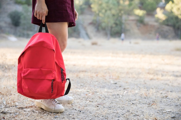 Jugendlicher, der in der Hand mit Rucksack in Park wartet