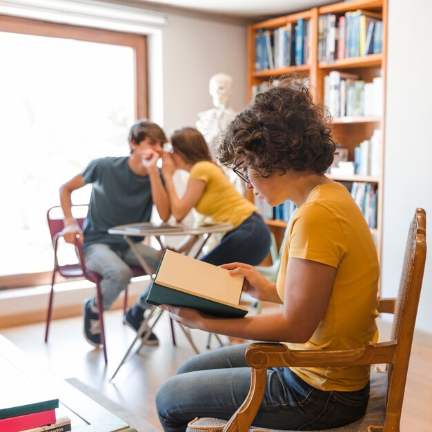 Jugendlicher, der nahe klatschenden Klassenkameraden liest