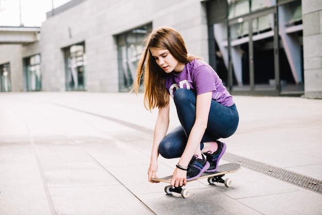 Jugendlicher, der Skateboard justiert