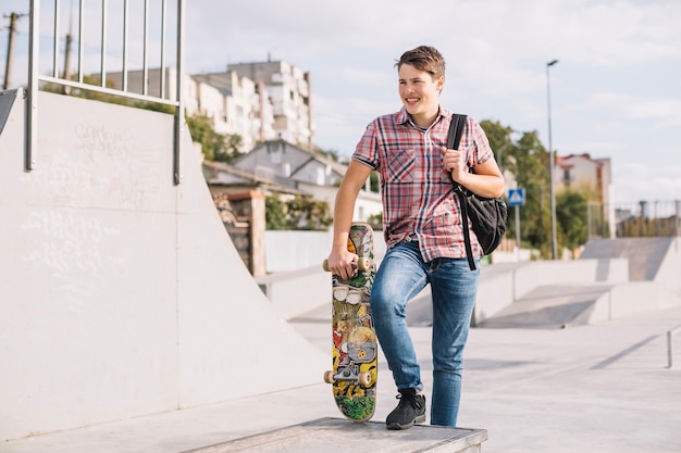 Jugendlicher mit dem Skateboard, das auf Grenze tritt