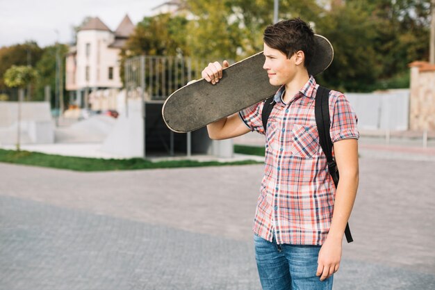 Jugendlicher mit dem Skateboard, das weg schaut