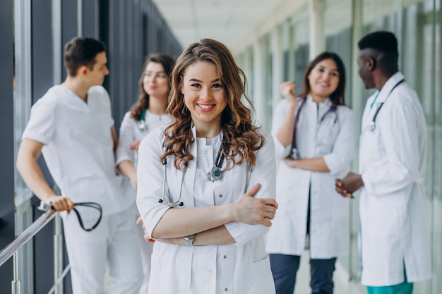 Kostenloses Foto junge ärztin, die im korridor des krankenhauses aufwirft