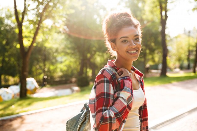 Junge afrikanische Frau, die draußen im Park geht.