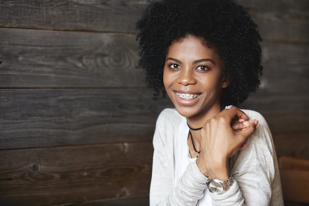 Junge afroamerikanische Frau, die im Café sitzt