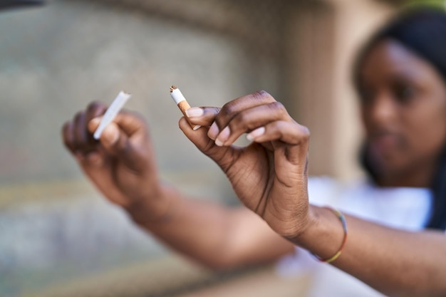 Kostenloses Foto junge afroamerikanische frau zerbricht zigarette auf der straße