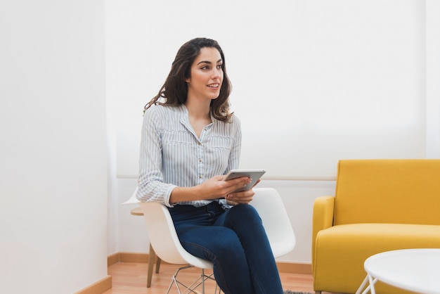 Junge Arbeitnehmer auf einem Stuhl sitzt und mit jemandem sprechen