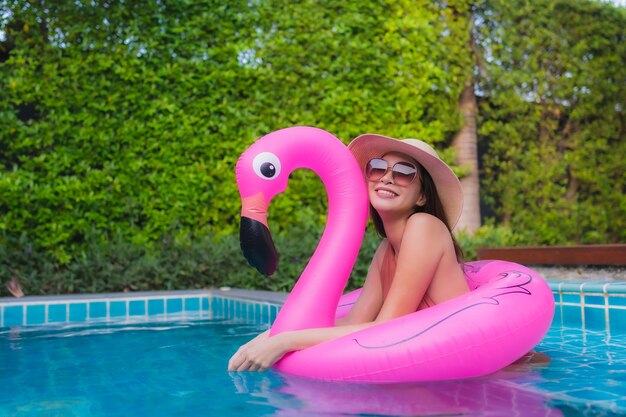 Junge asiatische Frau des Porträts entspannen sich glückliches Lächeln um Swimmingpool im Hotel