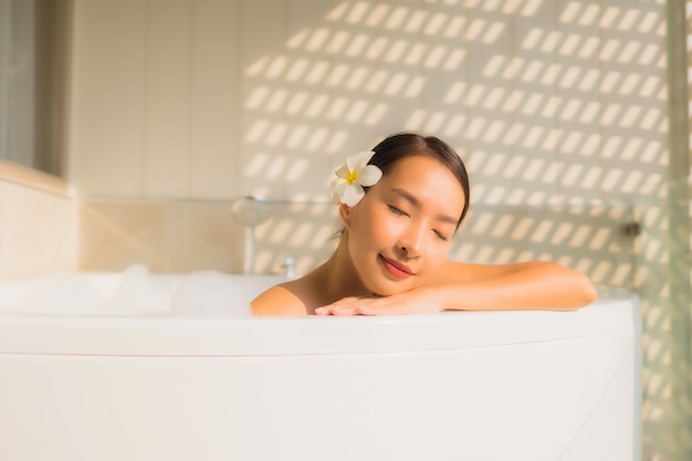 Junge asiatische Frau des Porträts entspannen sich nehmen ein Bad in der Badewanne
