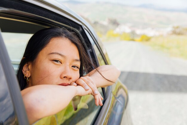 Junge asiatische Frau, die heraus Maschinenfenster schaut