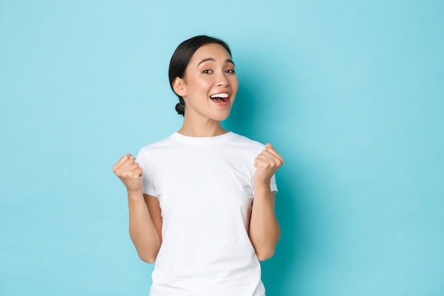 Junge asiatische Frau, die lässiges T-Shirt aufwirft