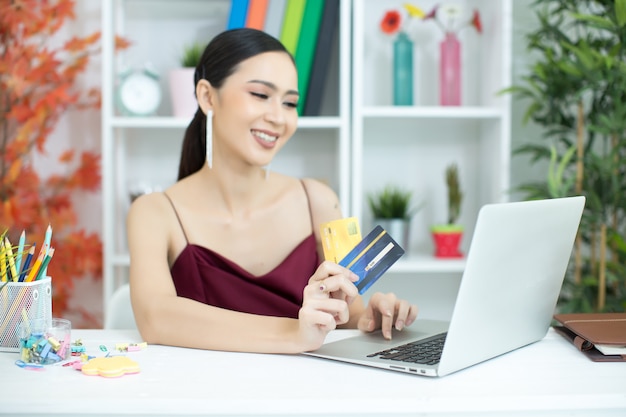 Junge asiatische Frau, die mit Kreditkarte zahlt
