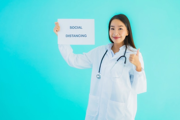 junge asiatische Ärztin mit Schild mit sozialer Distanzierung