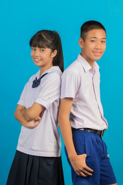 Junge asiatische Studenten und asiatische männliche Studenten stehen zusammen auf einem Blau.
