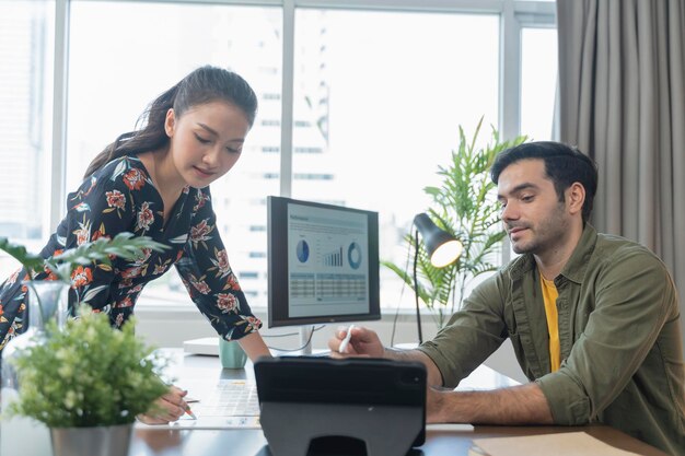 Junge asiatische und kaukasische erwachsene kreative Partnets, die mit neuen Projektdiskussions-Brainstormings am Bürotag arbeiten, Treffen von Designerpartnern, Konversation mit Fokus und Konzentration