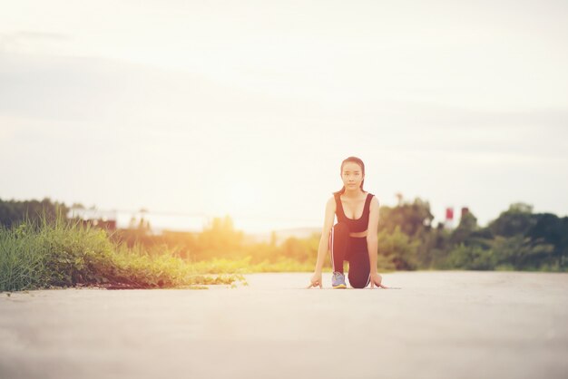 Junge Athletenfrau ist bereit, Lauf zu beginnen oder zu rütteln