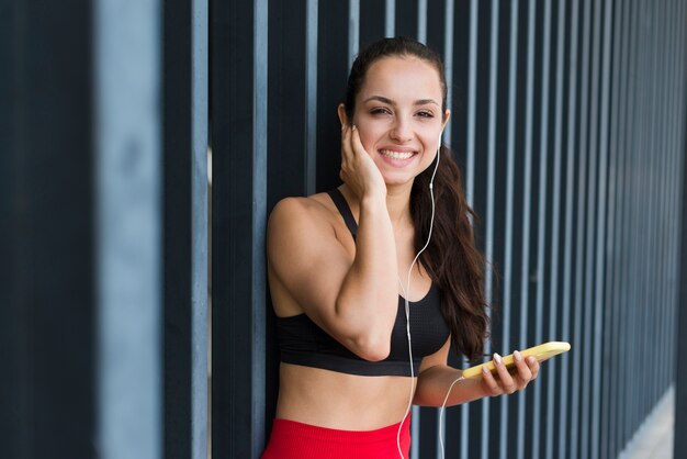 Junge Athletenfrau mit einem Smartphone