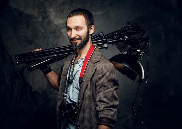 Junge attraktive Studentin trägt eine spezielle Lampe, während sie für den Fotografen posiert.