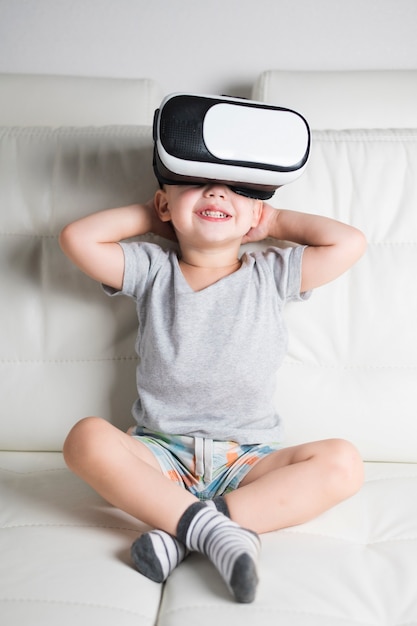 Junge auf Couch mit virtuellem Kopfhörer an