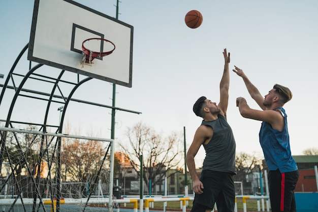 Junge Basketballspieler, die am Platz spielen