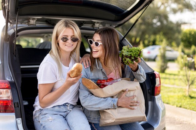 Junge beste Freunde, die in einem Autokofferraum hängen