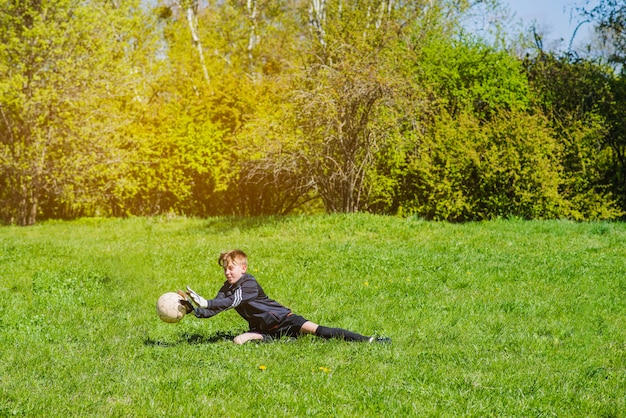 Junge blockiert den Ball mit den Händen