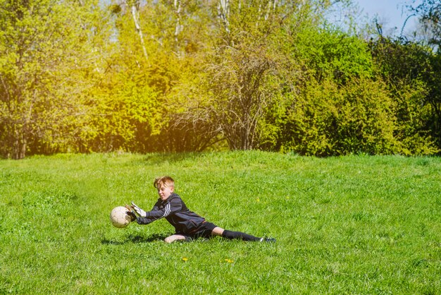 Junge blockiert den Ball mit den Händen