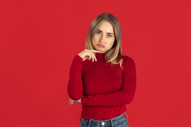 Junge blonde Frau auf roter Wand