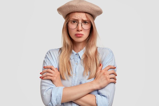 Junge blonde Frau, die blaues Hemd trägt