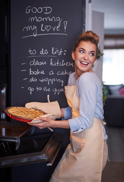 Junge blonde Frau, die Kuchen hält