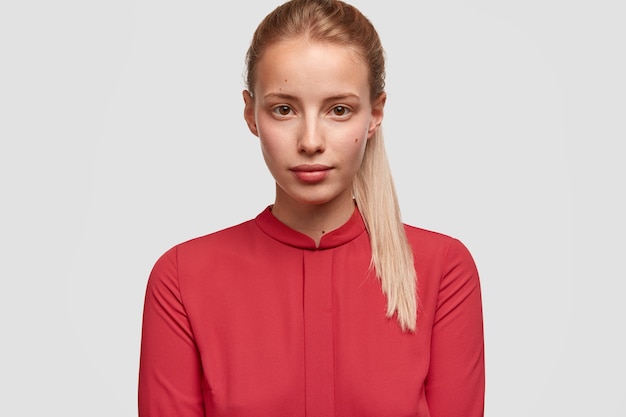 Junge blonde Frau, die rotes Hemd trägt