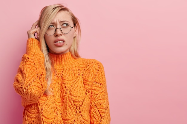 Kostenloses Foto junge blonde frau im orangefarbenen pullover