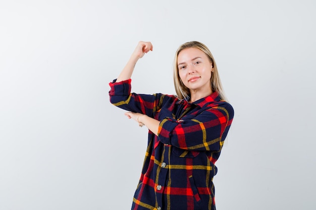 Junge blonde Frau in einem karierten Hemd