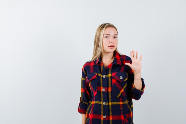 Junge blonde Frau in einem karierten Hemd