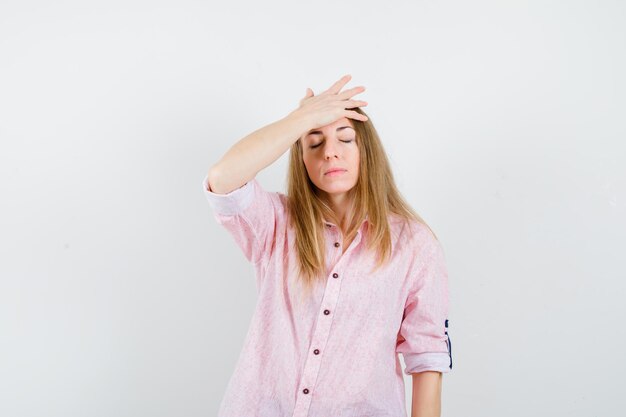 Junge blonde Frau in einem lässigen rosa Hemd