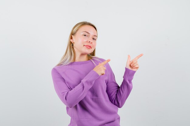 Junge blonde Frau in einem lila Pullover