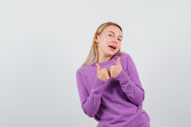 Junge blonde Frau in einem lila Pullover