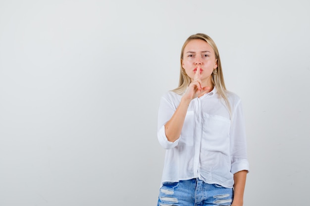 Junge blonde Frau in einem weißen Hemd