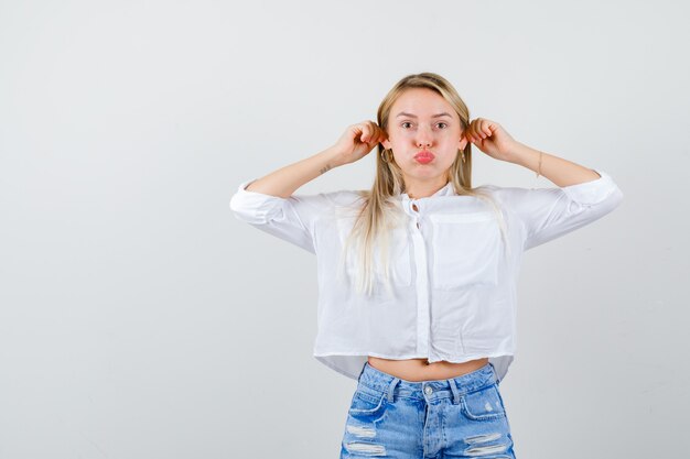 Junge blonde Frau in einem weißen Hemd