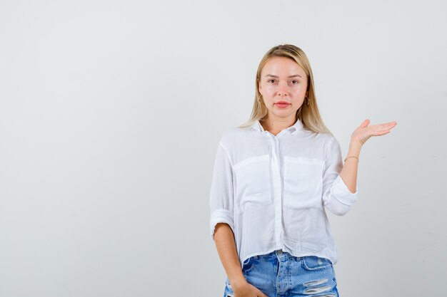 Junge blonde Frau in einem weißen Hemd