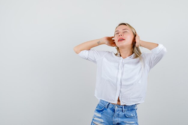 Junge blonde Frau in einem weißen Hemd