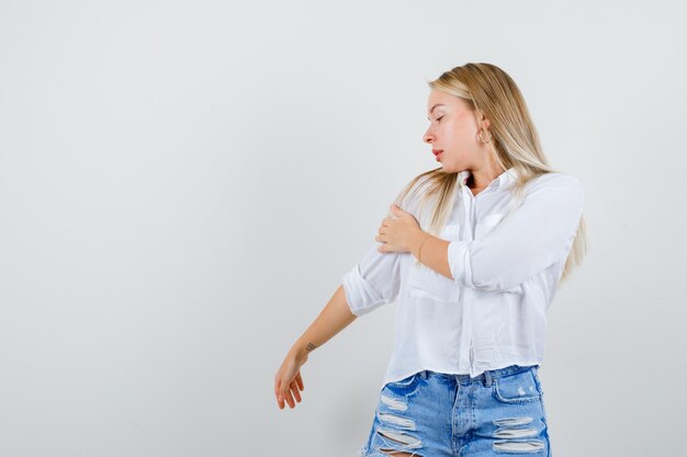 Junge blonde Frau in einem weißen Hemd