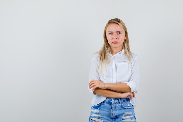 Junge blonde Frau in einem weißen Hemd