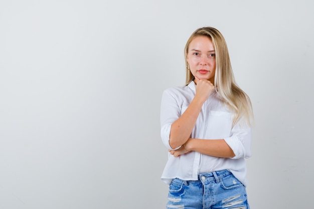 Junge blonde Frau in einem weißen Hemd